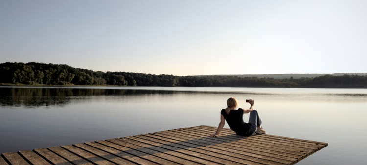 Woman taking a picture on a dock